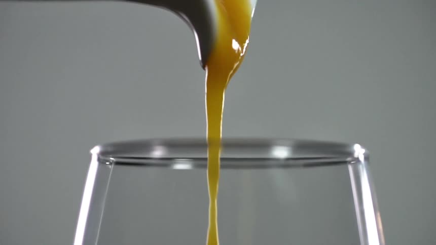 Black ceramic jar serves a yellow thick juice in a glass cup