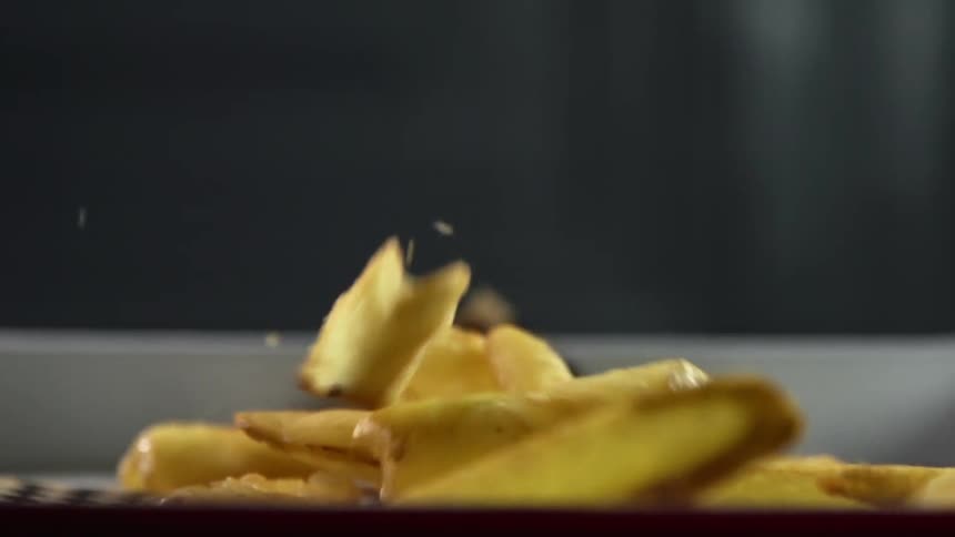 French fries falling on to a paper lined dish