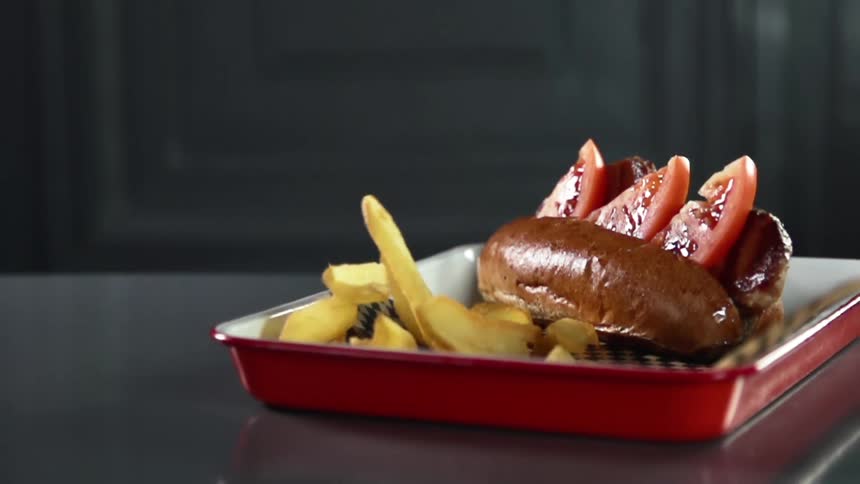 Thick cut fries are added to a burger entree on a long red plate