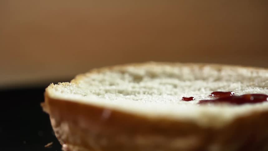 Ketchup is drizzled onto a half of hamburger bun