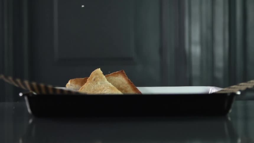 Two pieces of toast fall into a paper lined basket
