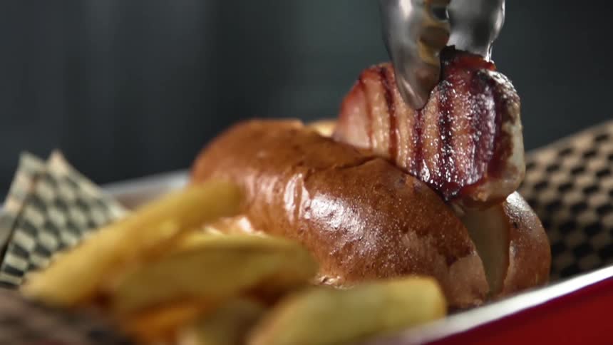 Juicy grilled meat is being put between a ban