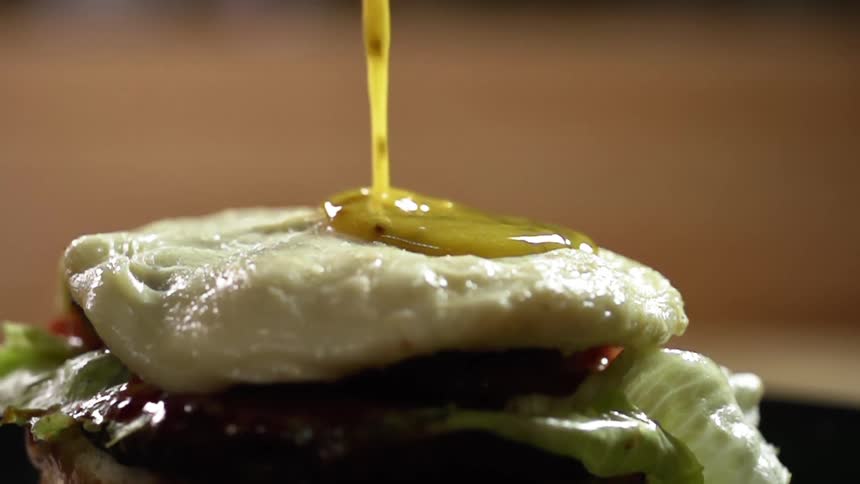 Sauce is poured on a burger