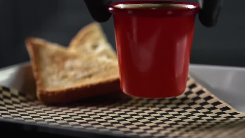 A person sets a container on a plate with bread