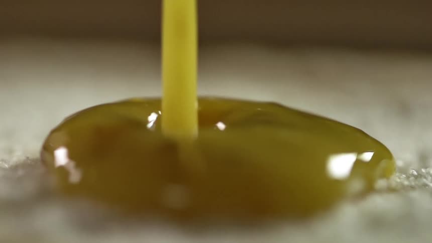 Sauce is poured onto a half of hamburger bun
