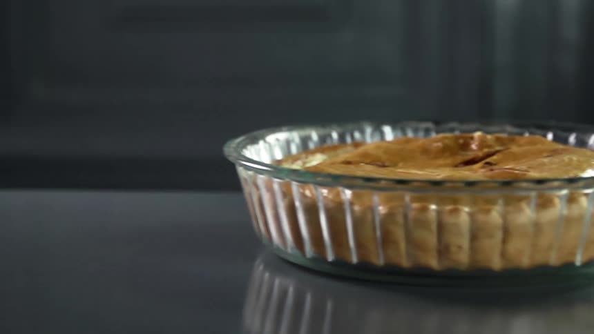 Baked pie inside a baking glass pan over the table