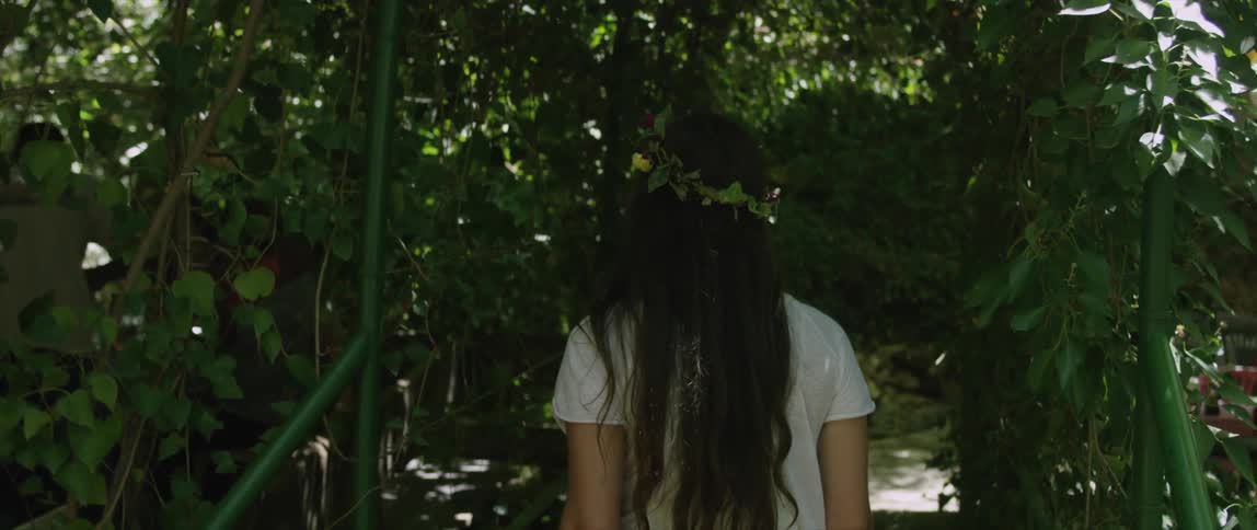 A woman is walking in the woods on a sunny day
