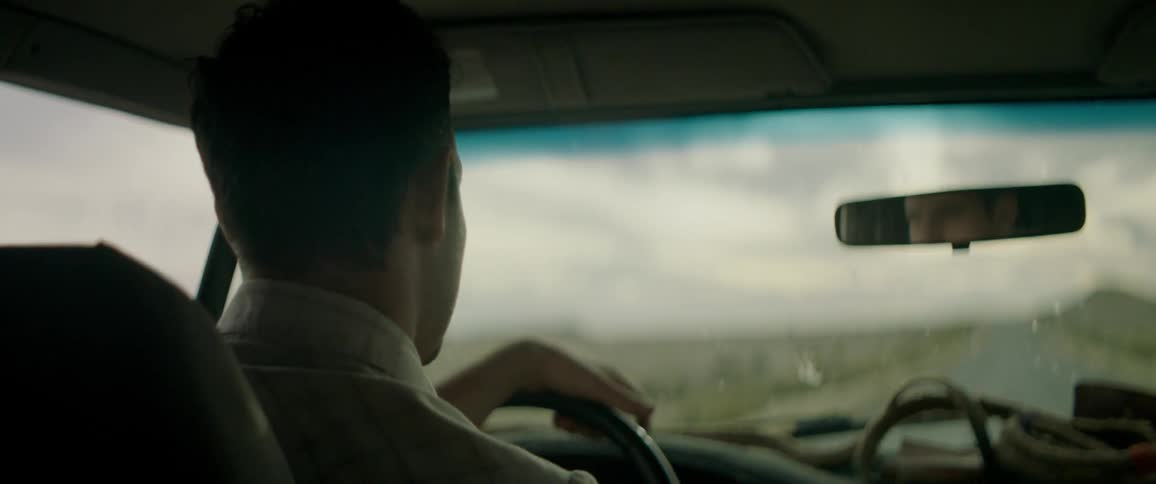 Man talks and adjusts mirror while driving vehicle