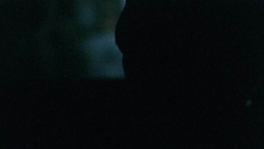 Child sits in passenger seat looking out window at building lights at night