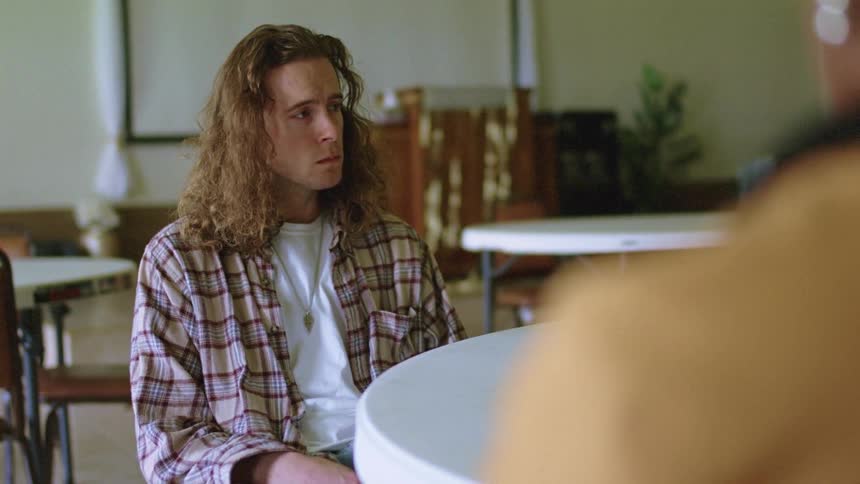 A man sits waiting by the table