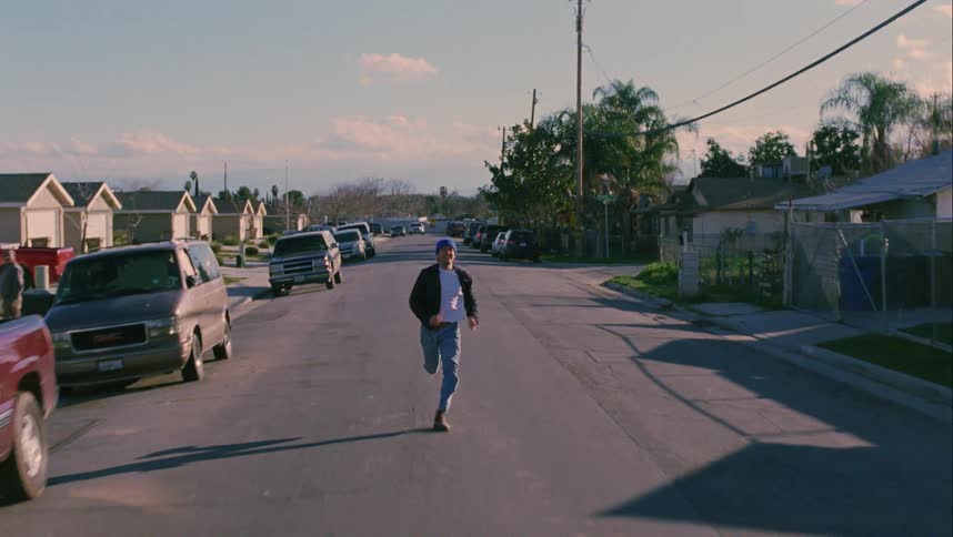 A young man runs down a small neighborhood road intensely