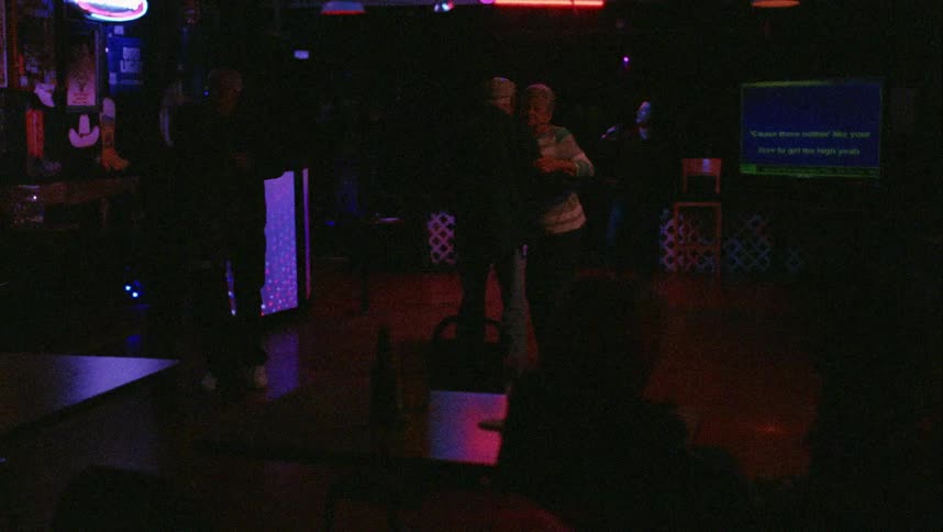 People sitting at tables watch couples dance near singer in bar