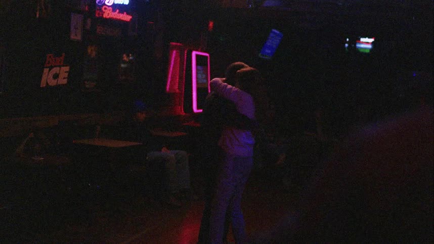 Young couple dancing in the dark dance floor of a night club