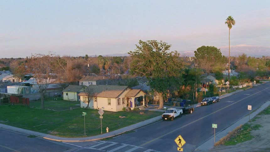 Aerial view of houses and vehicles in a neighborhood