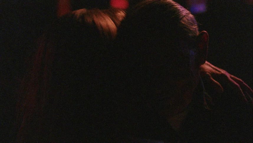 A man and a woman slow dancing in a room