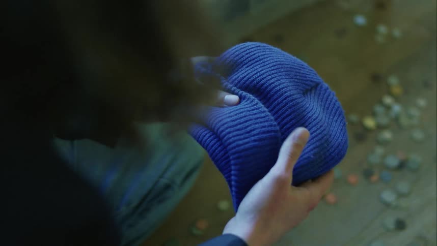 A teenager wipes dirt off his hat