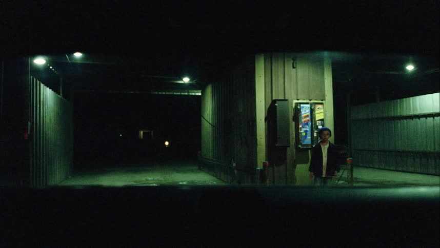 A man walking towards a car in a gas station leaving a boy behind