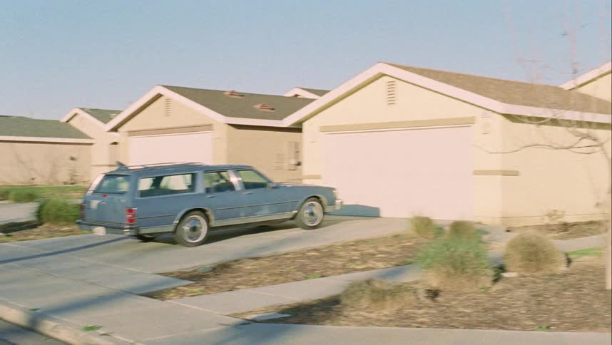 A car parked in front of a house in a neighborhood