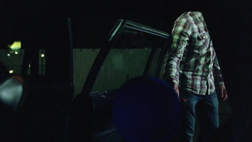 Man opens car door and insists child in knit cap take his hand and follow along