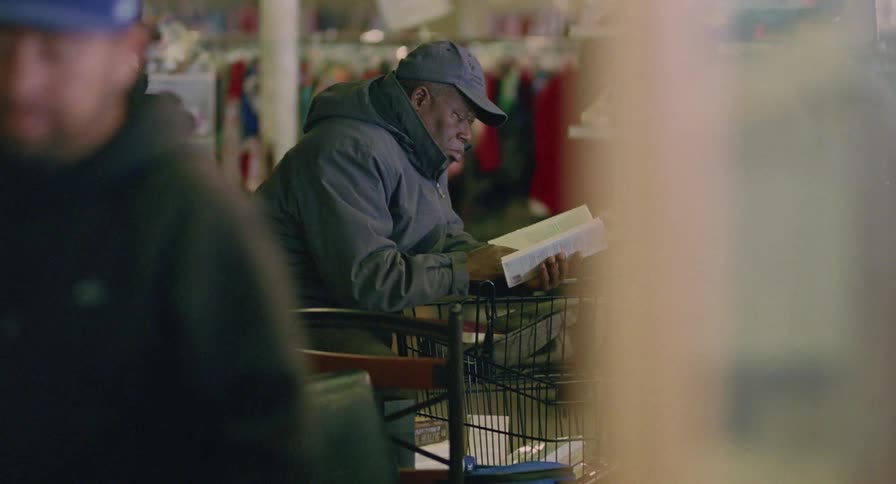 Man browsers through books as others shop around him