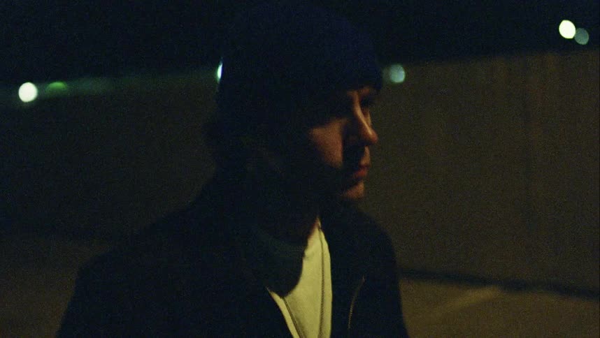 A man is walking outside at night