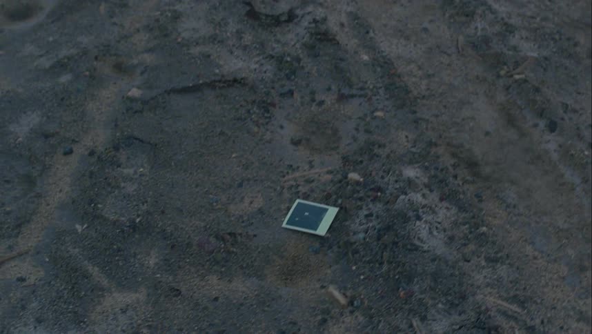 Man walking near tracks throws photograph on ground