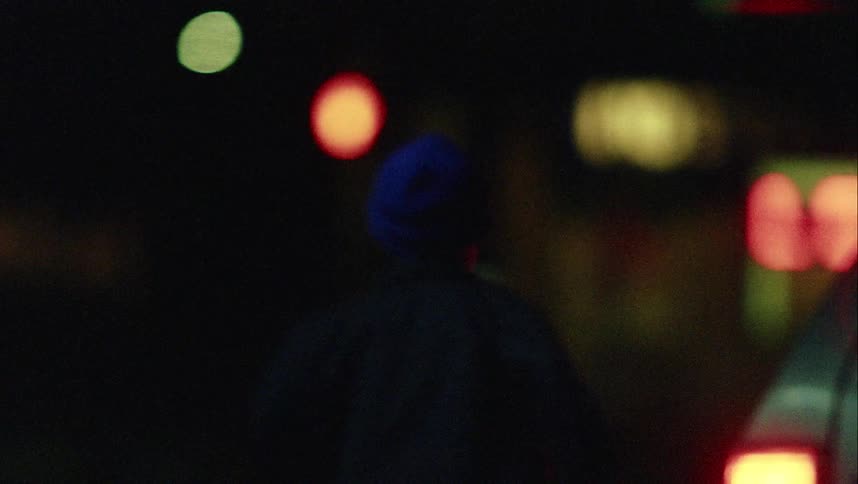 A little boy stands outside in the dark and then runs after a car as it drives away