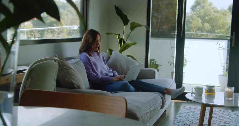 A woman is typing on her laptop