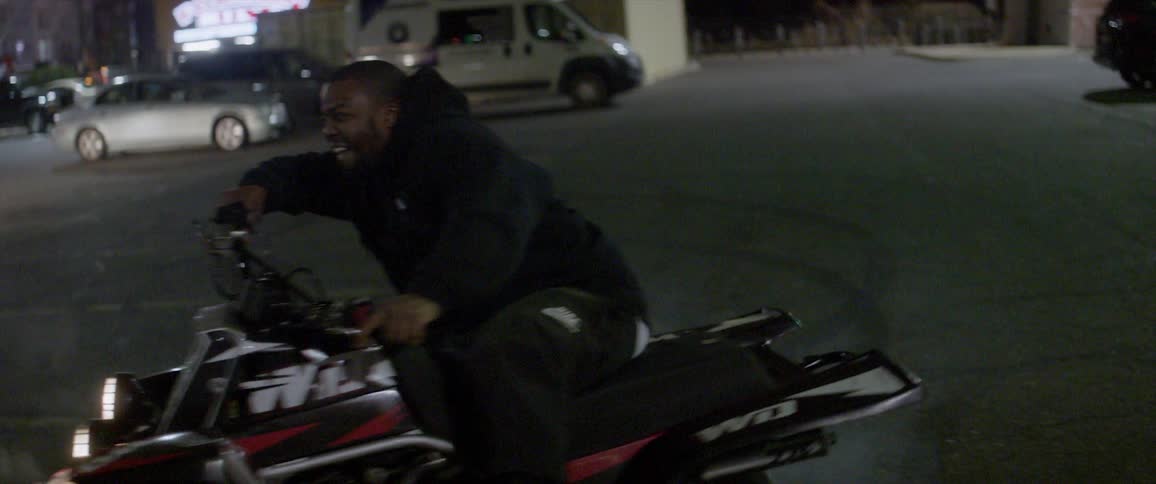 A man does donuts on the street while riding an atv