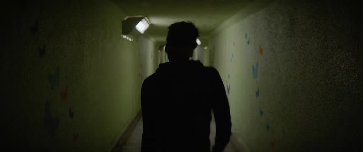 Man dances in a dimly lit hallway