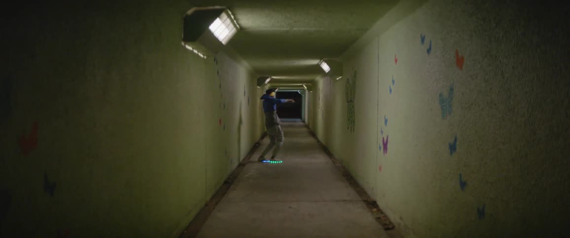 A man dances in a hallway with light up shoes