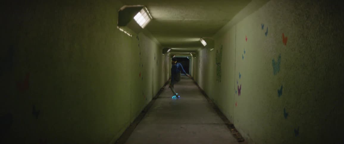 A man wearing light up shoes dances in the tunnel