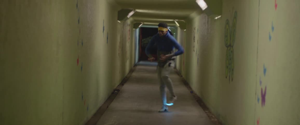 A man dances in a hallway with light up shoes