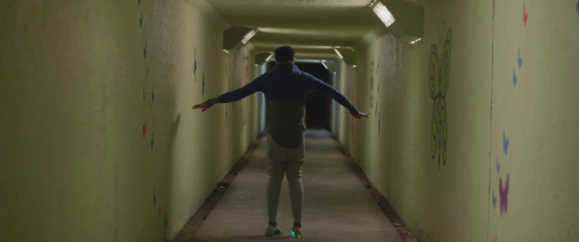 A man is dancing inside a tunnel at night