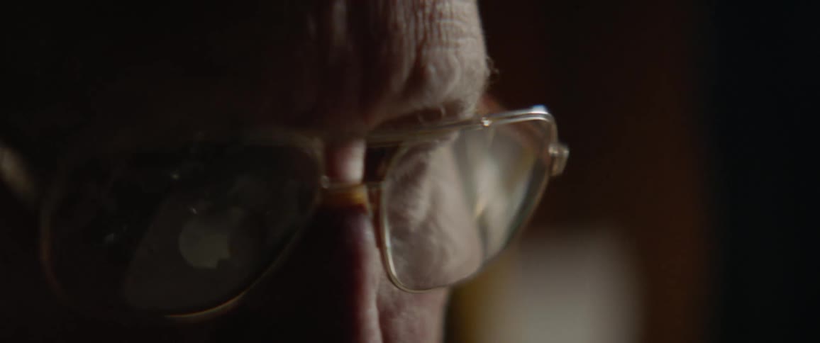 An elderly man is wearing glasses