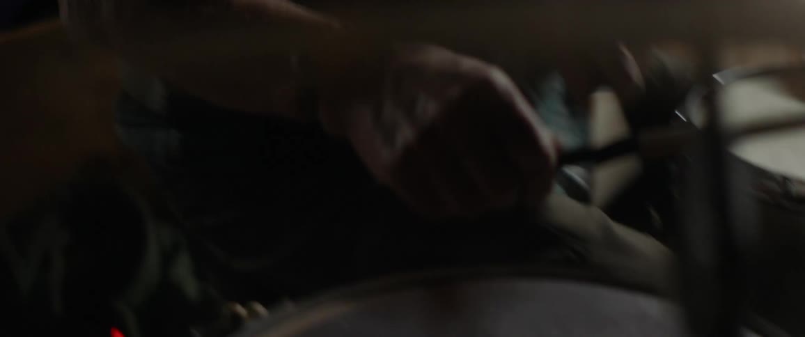A man plays drums in a garage