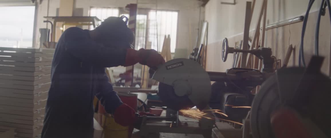 A man is using a circular saw to cut metal