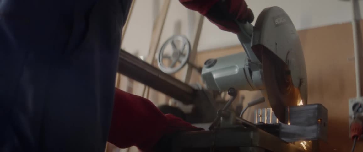 A man cuts into steel in a workshop