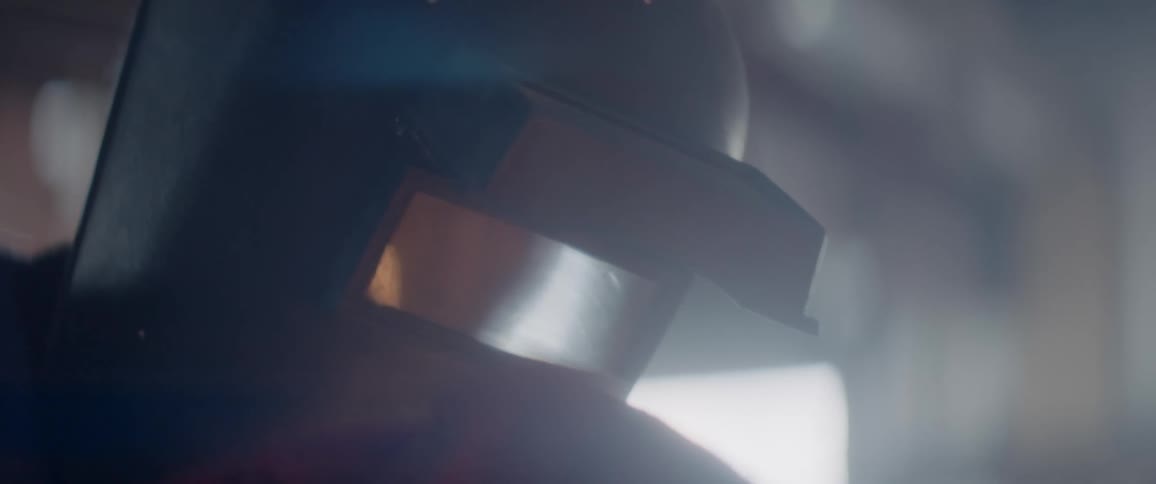 Sparks are reflected on the workers welding helmet