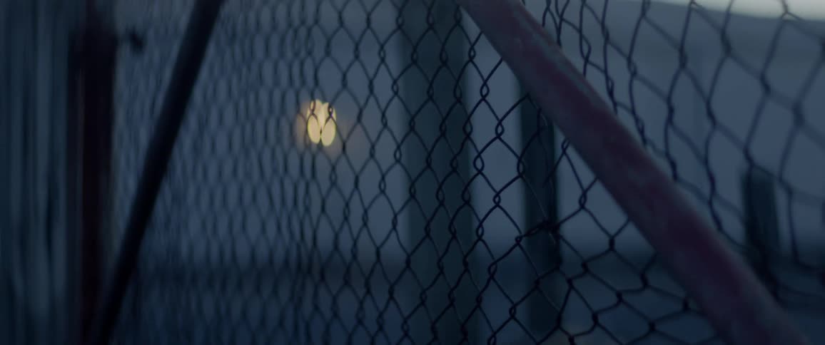 Chain link fence with a small light behind it