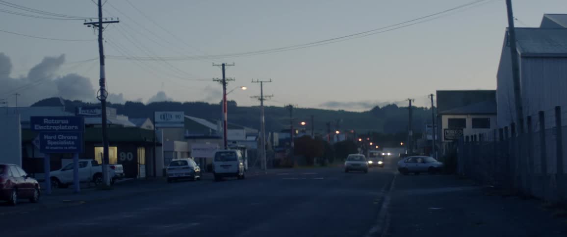 Vehicles travel down a street at night