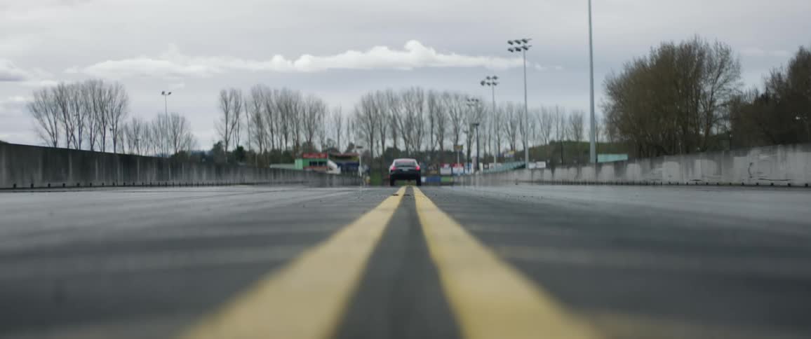 Car travels down the road over the striped yellow lines