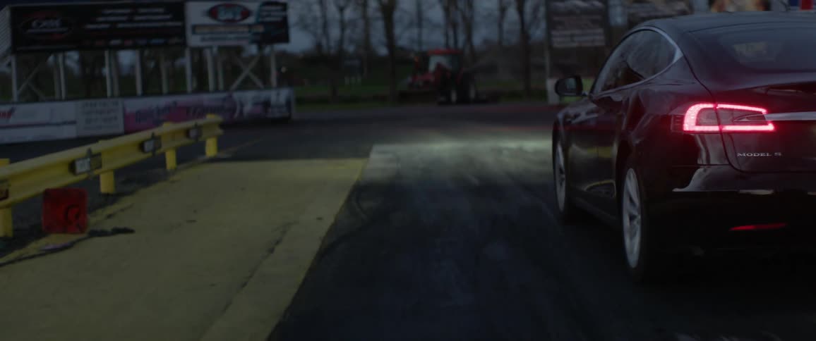 The car drives around the small road at sunset