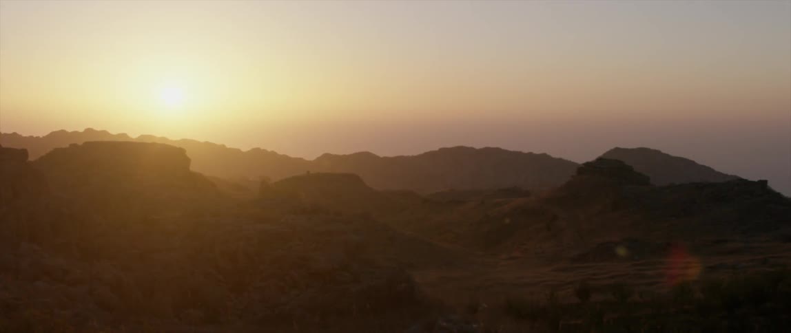 Aerial view of a hazy mountain range as the sun sets