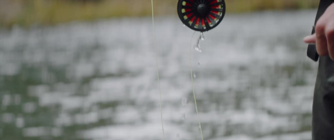 A fisherman stands in a river