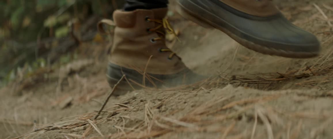 Hiker walks up a dirt hillside