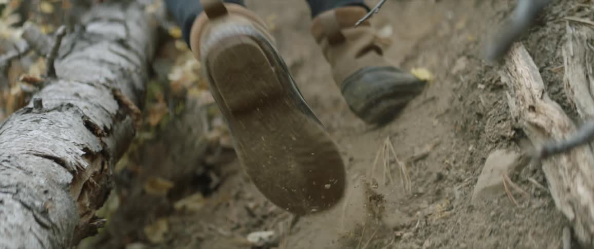 A hiker climbs up a dirt hill