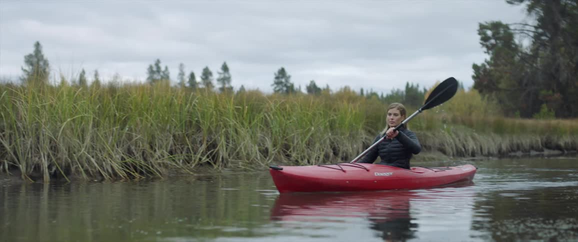 A woman kayaks on a river