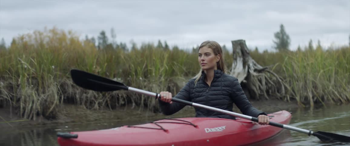 Woman kayaks on a river