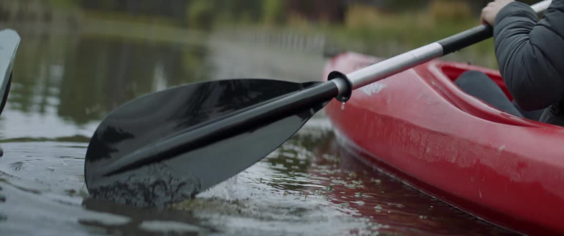Person paddles a kayak in a rider
